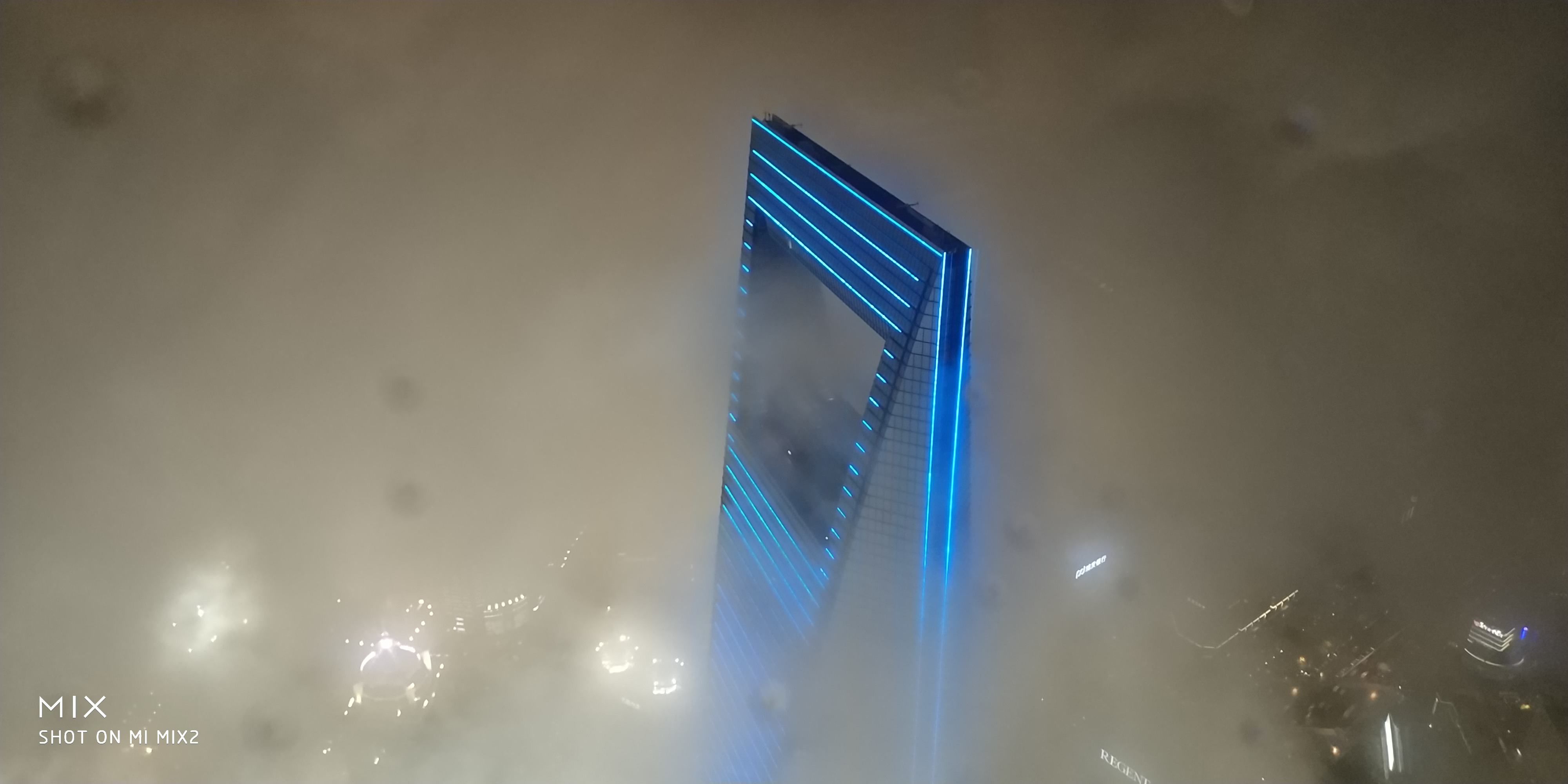 在云中的开瓶器，旁边的外星灯光是金茂大厦的楼顶